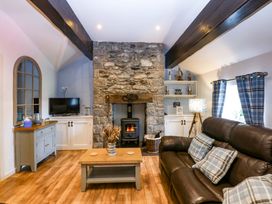 A living room with a fireplace and sofa at Cosy Cottage in Llandegfan near Menai Bridge