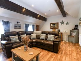 A living room with a sofa and coffee table at Cosy Cottage in Llandegfan near Menai Bridge