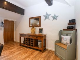 An entryway with a wooden table and a bench at Cosy Cottage Llandegfan near Menai Bridge