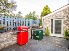 An outdoor space with a red refrigerator and a green utility box at Cosy Cottage in Llandegfan near Menai Bridge