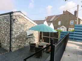 An outdoor patio with a table and chairs at Cosy Cottage in Llandegfan near Menai Bridge