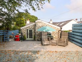 An outdoor seating area with chairs and a table at Cosy Cottage in Llandegfan near Menai Bridge