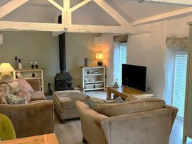 A living room with a sofa and television at Lavender Barn in Crantock