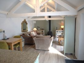 A living room with a sofa and dining table at Lavender Barn in Crantock