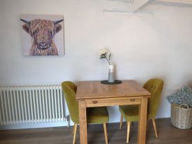 A dining room with a wooden table and yellow chairs at Lavender Barn in Crantock
