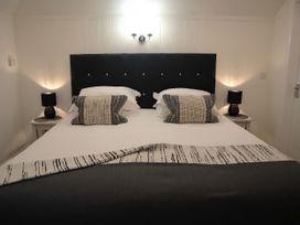 A bedroom with a bed and bedside tables at Lavender Barn in Crantock
