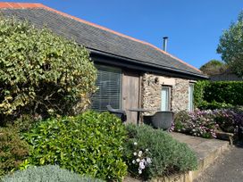 An outdoor seating area with flowers and shrubs at Lavender Barn Crantock