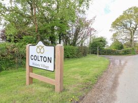 A road sign saying Colton Historic Village beside a country road with trees and grass at Shepherds Hut in Colton near Rugeley Staffordshire
