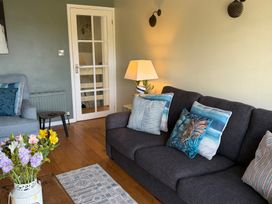 A living room with a sofa and flower vase at Ocean View in Downderry