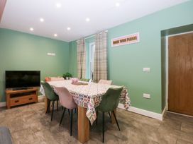 A dining room with a table and chairs at Tregynrig Bach Cemaes Bay