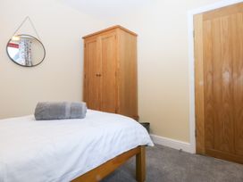A bedroom with a bed and wardrobe at Tregynrig Bach Cemaes Bay