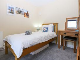 A bedroom with a single bed and a desk at Tregynrig Bach in Cemaes Bay