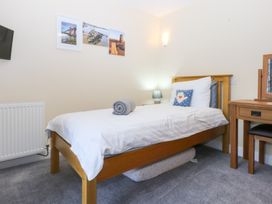 A bedroom with a bed and desk at Tregynrig Bach in Cemaes Bay
