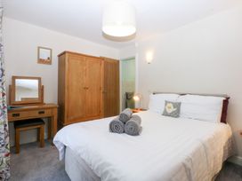 A bedroom with a bed and a wardrobe at Tregynrig Bach in Cemaes Bay