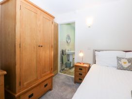 A bedroom with a wardrobe and bed at Tregynrig Bach Cemaes Bay
