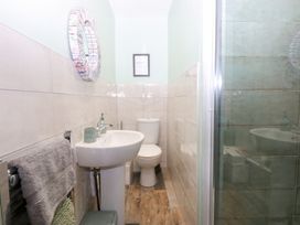 A bathroom with a wash basin, toilet, and shower at Tregynrig Bach in Cemaes Bay