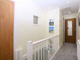 A hallway with a railing and pictures on the wall at Tregynrig Bach in Cemaes Bay