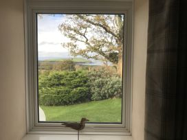 A view from a window with a bird figurine in a living room at Penllain, Newport, Pembrokeshire