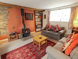 A living room with a stove and bookshelf at One Town End, Mungrisdale, Mosedale