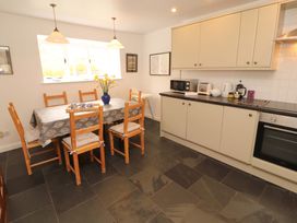 A kitchen with a dining table and wooden chairs at One Town End in Mungrisdale, Mosedale
