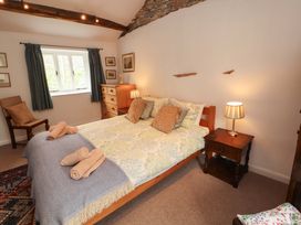 A bedroom with a bed, storage and side table at One Town End, Mungrisdale, Mosedale