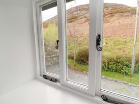 A window view showing a gravel area and trees at One Town End in Mungrisdale, Mosedale