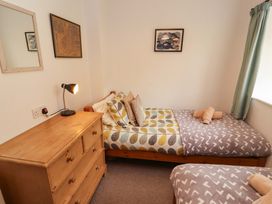 A bedroom with two beds and a dresser at One Town End in Mungrisdale, Mosedale