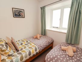 A bedroom with two single beds and a window at One Town End Mungrisdale, Mosedale