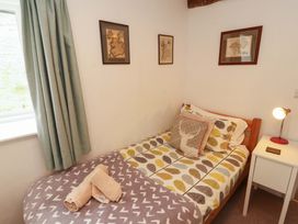 A bedroom with a bed and side table at One Town End, Mungrisdale, Mosedale