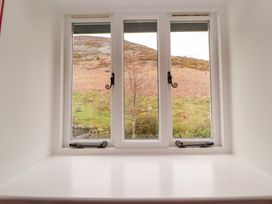 A window with a view of a mountain and tree at One Town End Mungrisdale, Mosedale