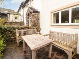 An outdoor area with wooden seating and a table at One Town End, Mungrisdale, Mosedale