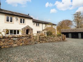 A house with a garage and stone wall at One Town End in Mungrisdale, Mosedale
