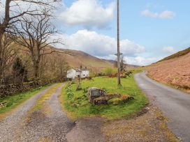 A rural road junction with a house and a sign at One Town End in Mungrisdale, Mosedale