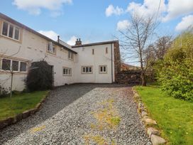 A garden with a gravel driveway and building at One Town End, Mungrisdale, Mosedale