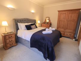 A bedroom with a bed, nightstands, and a wardrobe at Red Screes in Ambleside