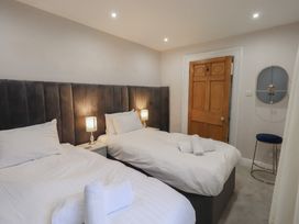 A bedroom with two beds and a wooden door at Red Screes in Ambleside