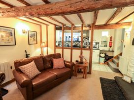 A living room with a sofa and kitchen view at Fellside Cottage in Bowness-On-Windermere