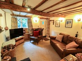 A living room with a television and sofas at Fellside Cottage in Bowness-On-Windermere