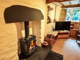 A living room with a wood stove and television at Fellside Cottage in Bowness-On-Windermere