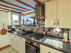 A kitchen with a stove and sink at Fellside Cottage Bowness-On-Windermere
