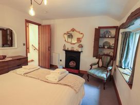 A bedroom with a bed and armchair at Fellside Cottage in Bowness-On-Windermere