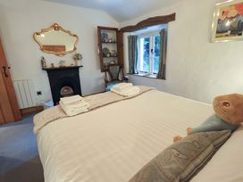 A bedroom with a bed and a mirror at Fellside Cottage in Bowness-On-Windermere