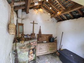 A storage area with a wooden cabinet and various tools at Fellside Cottage Bowness-On-Windermere