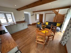 A living room with a kitchen area and dining table at Shires Rest Puxey near Sturminster Newton