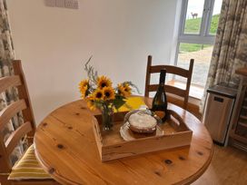 A dining room with a table set for two at Shires Rest in Puxey near Sturminster Newton