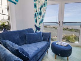 A living room with a sofa and view of the sea at Ocean View Apartment in Colwyn Bay