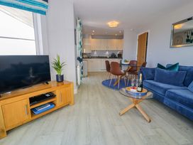 A living room with a sofa and television at Ocean View Apartment in Colwyn Bay