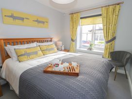 A bedroom with a bed and chair at Ocean View Apartment in Colwyn Bay