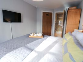 A bedroom with a bed and television at Ocean View Apartment Colwyn Bay