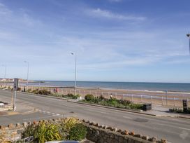 A view of the sea and beach with people walking at Ocean View Apartment in Colwyn Bay